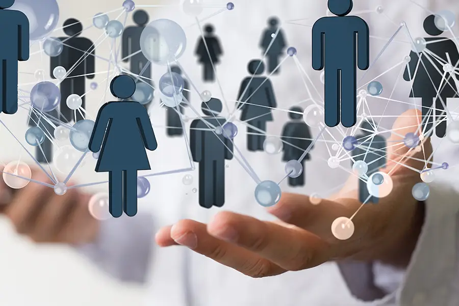 Conceptual image of a person holding out open hands beneath interconnected digital human avatars representing global networking, lead generation, and target demographics.